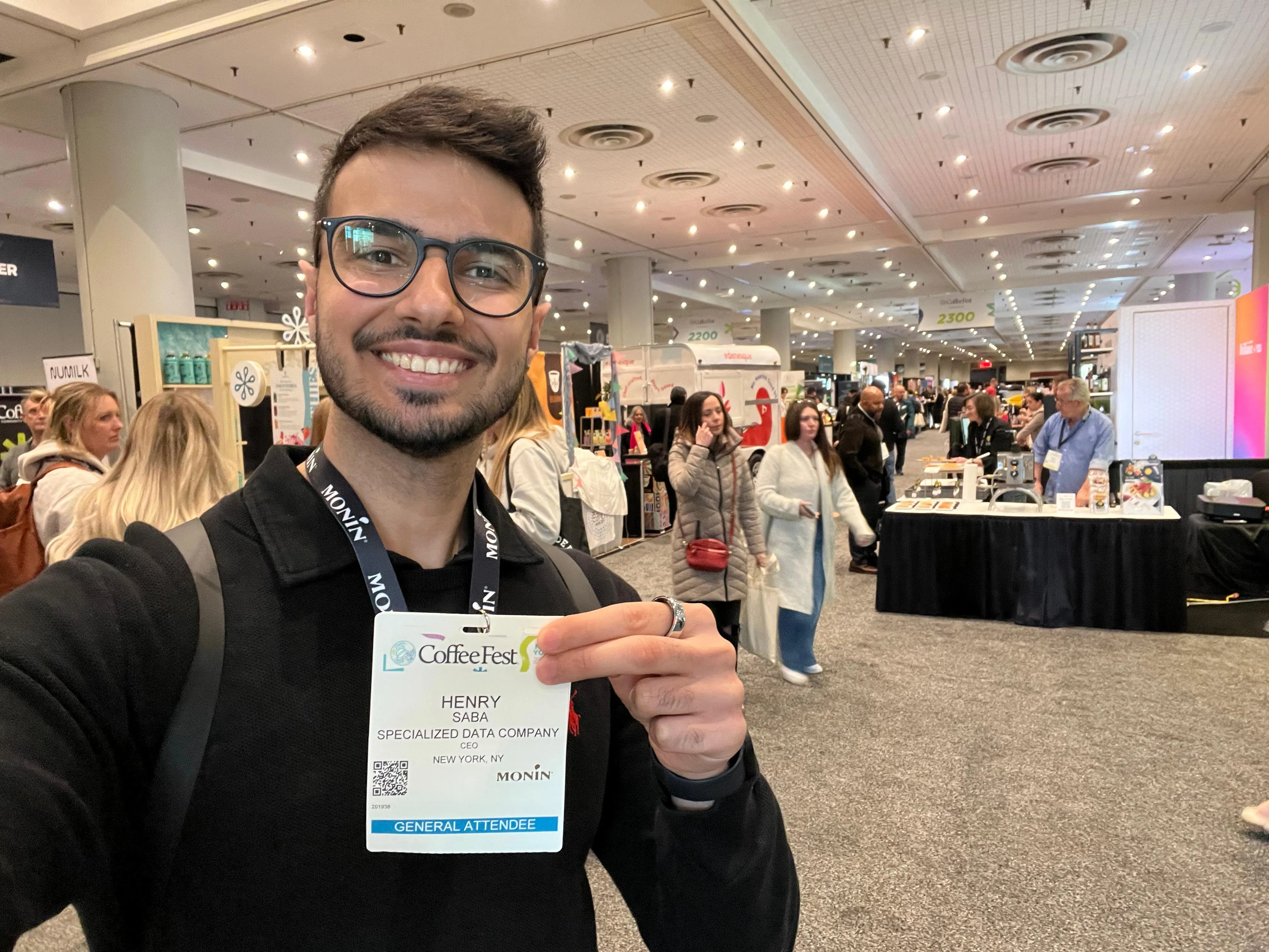 Selfie on the Coffee Fest New York 2025 show floor, holding an attendee badge